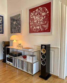 a living room with speakers and pictures on the wall