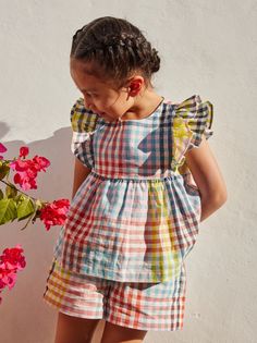 We absolutely love this elegant Paloma cotton/linen plaid top that looks dreamily springy. Design details include a fit-and-flare silhouette, pretty ruffle sleeves, a center back black button closure, and a delicate florals set on a creamy background. Pairs perfectly with matching shorts or camp shorts. Matching family styles are available in our Sibling Shop. Magical Childhood, Girls Frock Design, Kids Fashion Dress, Plaid Top, Vestidos Vintage, Stylish Kids, Ruffle Sleeves, Baby Sewing