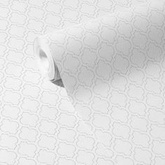 a roll of white wallpaper with an intricate pattern on the top and bottom half