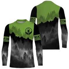 a green and black long sleeve shirt with trees on the mountain in the foggy sky