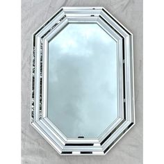 a mirror that is sitting on top of a table with clouds in the sky behind it