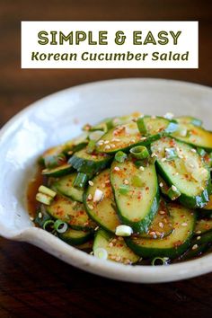 a white bowl filled with cucumber salad on top of a wooden table