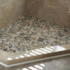 a tiled shower stall with stone floor and walls