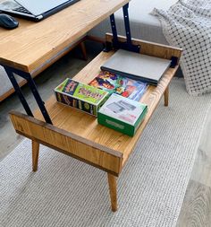 a wooden table topped with books next to a laptop computer on top of a desk