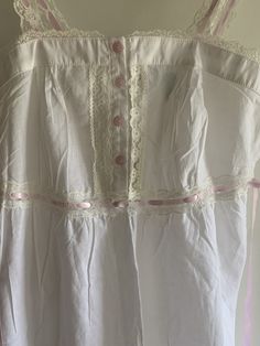 Very cute and summery vintage Laura Ashley nightgown  NWT in pink and white! Cute floral pink buttons Pink ribbon straps do not adjust Ties at back.  Underbust at is slightly elasticized.   Lightgweight cotton.  Super summery! Medium size per tag Bust flat at front is 16 inches Underbust is 15 inches.  Elasticized at back.  Length is 44-45 inches.  Final sale. No returns🌺🌺 Summer Sleepwear With Buttons, Cotton Cottagecore Sleepwear For Sleepovers, Cottagecore Cotton Sleepwear For Sleepover, Spring White Cotton Nightgown, White Buttoned Dress For Loungewear, White Cotton Spring Nightgown, Summer Nightgown With Buttons, White Cotton Cottagecore Sleepwear, White Cotton Cottagecore Nightgown