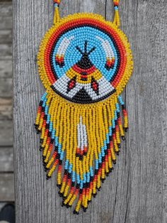 a colorful beaded necklace hanging on a wooden fence