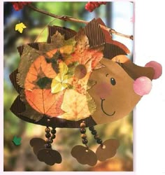 an image of a fall decoration with leaves on the wind chime hanging from a tree branch