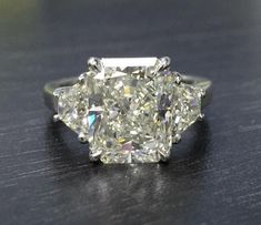 a three stone diamond ring sitting on top of a table