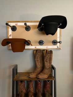 cowboy boots and hats are hanging on the wall next to a coat rack with hooks