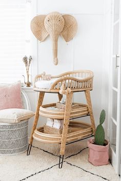 an elephant head hanging on the wall above a baby crib in a white room