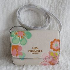 Coach Dreamy Land Floral Leather Mini Brynn Crossbody (C8324) White (Cream) Leather With White Graphic Floral Print. Push Lock Closure. Two Credit Card Slots. Interior Zip Pocket. Exterior Slip Pocket. 21.5" Shoulder Strap. Gold Hardware. 7.25" (L) X 5.25" (H). Coach Mini Bag, Graphic Floral, Girly Bags, Leather Mini, White Cream, Coach Bags, Gold Hardware, Mini Bag, Card Slots