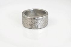 a silver ring sitting on top of a white table