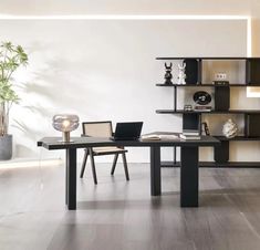 a black table with a laptop on top of it in front of a book shelf