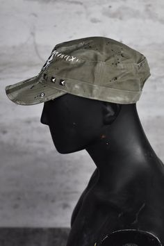 Introducing the Melting Skull Field Cap - the epitome of apocalyptic style and edgy streetwear. This dystopian cap is not your average everyday headwear; it's a statement piece that will set you apart in any post-apocalyptic landscape. Made from top-noch cotton. Crafted with meticulous attention to detail, this field cap features subtle distressing, rugged frayed edges, visible stitching, and square studs, adding to its gritty and unique charm. The apocalyptic clothing aesthetic is perfectly captured in this project. The centerpiece of this cap is the mesmerizing melting skull patch, a hauntingly beautiful symbol of the post-apocalyptic world. It serves as a reminder of the edginess and individuality that come with embracing the apocalyptic style. Whether you're looking for sun protection Military Style Hat For Streetwear, Military Style Flat Cap For Streetwear, Alternative Style Adjustable Cap, Adjustable Alternative Style Cap, Military Visor Hat For Streetwear, Military Style Visor Hat For Streetwear, Punk Style Cap For Festivals, Alternative Adjustable Hat For Festivals, Punk Style Festival Cap