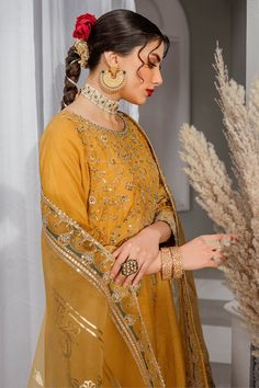 Luxury Mustard Yellow Pakistani Embroidered Salwar Kameez is a simplistic outfit in a mustard shade is crafted on raw silk. The artfully composed neckline, sleeves and hem features, golden embellishments, contrasting color embroidery and lace and tassel detailing, Embroidered Kameez: The beautiful Salwar Kameez comes in a beautiful mustard color and is emblazoned with intricate designs and fine details of embroidery. Floral designs, motifs, and hand-crafted details of sequins, stones, and tilla Gold Dola Silk Sets With Mirror Work, Gold Saree Dress With Mirror Work, Diwali Gold Embroidery Straight Kurta Salwar Kameez, Diwali Salwar Kameez With Gold Embroidery, Diwali Gold Embroidery Straight Salwar Kameez, Festive Gold Lehenga With Dabka Detailing, Designer Gold Anarkali Set With Embroidery, Gold Lehenga With Dabka For Festive Occasions, Gold Unstitched Designer Wear Sets