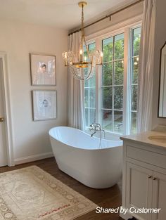 a large white bath tub sitting next to a window