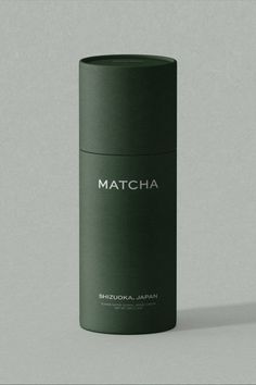 a green canister with the word matcha written on it in white lettering, against a gray background