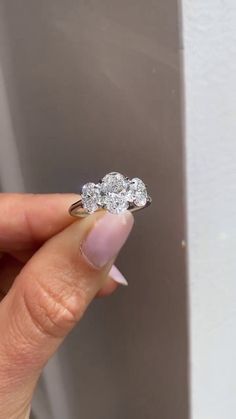 a woman's hand holding an engagement ring