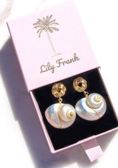 Dive into the mesmerizing allure of our Natural Nautilus Shell Earrings, inspired by the enchanting beauty of the ocean. Each sustainable and reworked shell is adorned with a singular freshwater pearl, reminiscent of treasures found along the shore. Impeccably designed, this one-of-a-kind piece captures the essence of oceanic elegance. Choose your favorite from three distinct post options - whether it's the chic gold knot or the classic gold shell with push backing, or the oval drop with conveni Cheap White Shell Earrings, Affordable Gold Shell Earrings, Luxury Shell-shaped Jewelry, Cheap Elegant Shell Earrings, Luxury White Shell Jewelry, Luxury Summer Earrings As Gift, Luxury Elegant Earrings For Summer, Luxury Gift Earrings With Unique Design, Luxury Chic Earrings For Gift