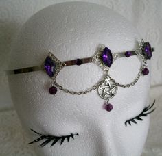 This beautiful circlet has three sterling silver plated filigree accents with purple faceted glass settings, purple faceted bead drops, rhinestones, pewter silver pentacle and metal chain. Adjustable. Purple Metal Jewelry For Halloween, Silver Gothic Headpiece For Festivals, Silver Fantasy Costume Jewelry, Gothic Adjustable Body Jewelry For Festivals, Mystical Purple Jewelry For Festivals, Gothic Purple Metal Jewelry, Silver Fantasy Crown-shaped Jewelry, Fantasy Style Amethyst Purple Jewelry, Silver Crown Fantasy Jewelry