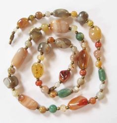 This is a gorgeous natural agate beaded necklace from the 1970's at my best estimate. The necklace is not marked or signed, but these pieces were very popular in the 1960's and 1970's. The necklace is 24 inches long. The largest agate bead is 7/8 inch by 1/2 inches.  The small round agates are 7 mm. The beads are spaced with tiny brass spacer beads. The necklace is in very good condition. The agates are free of chips, cracks, scratches, or scuffs. The brass barrel clasp functions well. The only Vintage Natural Stones Beaded Necklaces, Vintage Beaded Necklaces With Natural Stones, Vintage Agate Beaded Necklace With Colorful Beads, Vintage Agate Beaded Necklaces With Large Beads, Vintage Agate Necklaces With Polished Beads, Vintage Agate Beaded Necklaces, Vintage Agate Necklaces With Colorful Beads, Vintage Agate Beaded Necklace With Large Beads, Handmade Vintage Agate Beaded Necklaces