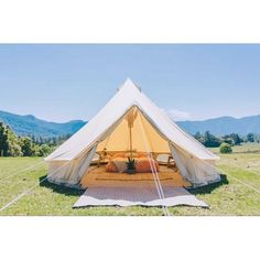 a white tent sitting on top of a lush green field