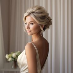 a woman with blonde hair wearing a white dress and posing in front of a window