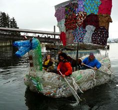 three people in a boat made out of plastic bottles and other items floating on the water