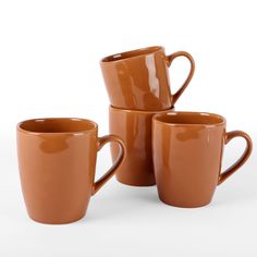 four brown coffee mugs stacked on top of each other