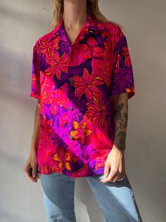 "- Vintage 1970s Tia button up shirt - Bright pink floral pattern - Feels like poly or acrylic - Medium  Chest: 22\" Length: 26\"" Pink Collared Hawaiian Shirt For Beach, Pink Printed Button-up Shirt, Retro Pink Top With Retro Print, Pink Floral Print Button-up Shirt, Retro Pink Printed Shirt, Pink Tropical Top With Camp Collar, Pink Floral Print Beach Shirt, Beach Pink Floral Print Shirt, Pink Hawaiian Shirt With Tropical Print