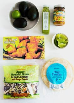 ingredients to make tortillas laid out on a white table with limes, avocado, salt and pepper