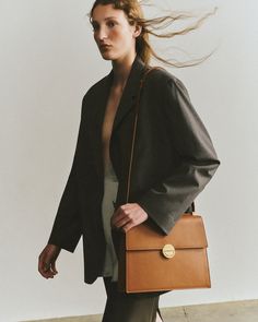 Named for South Korean poet, artist and activist Na Hye Seok, this Objets Daso bag exudes understated sophistication with its sharp, angular lines, polished goldtone hardware and calfskin leather construction. The top-flap silhouette is fastened with a signature push-lock closure to keep items stored safely in the pocketed interior. Signature push-lock closure Adjustable shoulder strap Goldtone hardware Two interior pockets Outer: 100% calfskin leather Lining: 100% lambskin leather Store in dust bag Made in Italy Measurements Width: 11.41in Height: 8.66in Depth: 1.81in | Objets Daso Women's Hye Crossbody Bag in Tan | Leather Leather Store, South Korean, Lambskin Leather, Tan Leather, Bag Making, Purses And Handbags, Leather Shoulder Bag, Calf Skin, Crossbody Bag