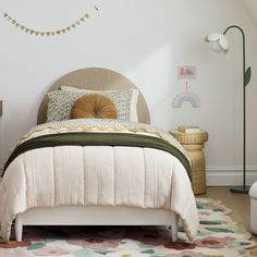 a bedroom with a white bed and colorful rugs