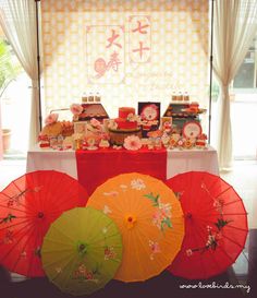 there are three umbrellas on the table with other items in front of it,