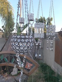 a glass chandelier hanging from the side of a wall next to a fence