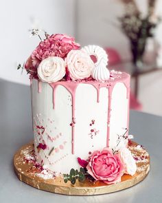 a white and pink cake with flowers on top