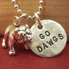 a dog charm with the words go dawgs on it