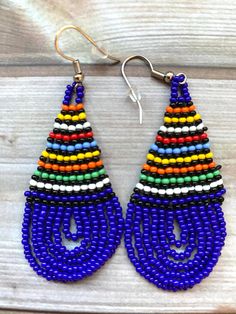 💫 Beautiful beaded earrings handmade in South Africa by Zulu women. 💫 Bold, bright ethnic colours, these earrings are a teardrop shape with intricate beading detail. 💫 Unusual, understated yet still glamorous! 💫 Each design is unique and hand beaded using traditional techniques. 💫 Earrings have a stainless steel, nickel-free hook and an additional rubber stopper. More about us Our products are all hand-made, by artists and crafters in South Africa. We source suppliers with the highest quali Traditional Colorful Beaded Earrings For Festival, Traditional Blue Beaded Earrings, Traditional Large Beads Earrings, Vibrant Beaded Earrings As A Gift, Vibrant Beaded Earrings For Gifts, Traditional Colorful Round Bead Earrings, Traditional Tiny Beads Earrings, Traditional Multicolor Earrings With Large Beads, Traditional Multicolor Beaded Earrings