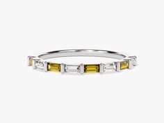 a yellow and white diamond ring with three stones on each side, set in 18k white gold