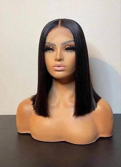 a wig with long black hair sitting on top of a table