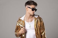 a man wearing sunglasses and a gold jacket