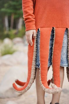 a person wearing an orange octopus costume and black shoes with their feet in the air