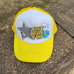 a yellow and white hat that says just have fun on it sitting on the ground