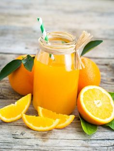 orange juice in a glass jar surrounded by sliced oranges