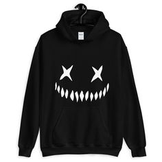 "Get creepy and cozy in this Creepy Pumpkin Face Horror Hoodie. Unisex fit with a large pocket and double lined hood. Everyone needs a cozy go-to hoodie to curl up in, so go for one that's soft, smooth, and stylish. It's the perfect choice for cooler evenings! * 50% cotton, 50% polyester  * Double-lined hood * Double-needle stitching throughout  * Air-jet spun yarn with a soft feel and reduced pilling * 1x1 athletic rib knit cuffs and waistband with spandex * Front pouch pocket  Sizes (inches)   Small - (Width: 20\"- Length: 26\")  Medium - (Width: 22\" - Length: 27\")  Large - (Width: 24\" - Length: 28\")  XL - (Width: 26\" - Length: 29\")  XXL - (Width: 28\" - Length: 30\")  XXXL - (Width: 30\" - Length: 31\")  (unavailable in Green)  XXXXL - (Width: 32\" - Length: 32\") (unavailable in Horror Hoodie, Smiley Face Sweatshirt, Rave Aesthetic, Goth Rave, Creepy Pumpkin, Horror Artwork, Neutral Tops, Cute Hoodie, Sweatshirt Zipper