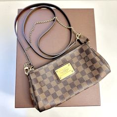 Louis Vuitton In Very Condition And 100 % Authentic Louis Vuitton Eva Damier Ebene Cross - Body Clutch & Dust Bag. Features Gold Hardware , Zipper Closure , Can Wear As A Clutch Or Crossbody Bag , Hairline Scratches On Front Logo Hardware And Some Signs Of Regular Wear In Interior And Exterior. Overall In A Very Good Condition. Comes With Original Dust Bag And Box. Measurements : W 9 " X H 5 ″ Depth 1.5 ″ Louis Vuitton Eva, Damier Ebene, Authentic Louis Vuitton, Gold Hardware, Louis Vuitton Bag, Interior And Exterior, Cross Body, Bags Handbags, Crossbody Bag