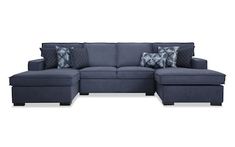 a blue sectional couch with pillows on it