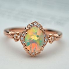 Natural opal engagement ring halo rose gold vintage inspired Ethiopian Opal Oval Ring For Wedding, Oval Rose Gold Opal Gemstone Ring, Rose Gold Oval Opal Gemstone Ring, Rose Gold Oval Opal Ring, Unique Oval Opal Ring For Anniversary, Elegant Ethiopian Opal Oval Rings, Opal Oval Diamond Ring With Gemstone, Oval Opal Diamond Ring With Gemstone Details, Oval Opal Diamond Ring With Gemstone