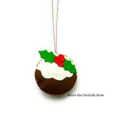 a christmas cookie ornament hanging from a red and green cord on a white background