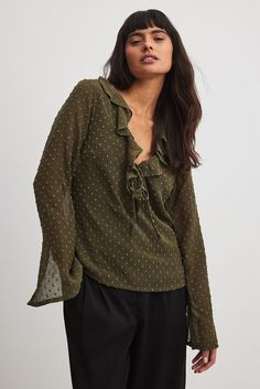 This blouse features a flowy fit and slightly sheer fabric. It has a V-neck with a frill design and a self tie detail and trumpet sleeves with a slit detail at the cuffs. Our blouse features a lining. Trumpet Sleeves, Frill Blouse, Trumpet Sleeve, Sheer Fabric, Green Blouse, Sheer Fabrics, Na Kd, No Frills, Shirt Blouses